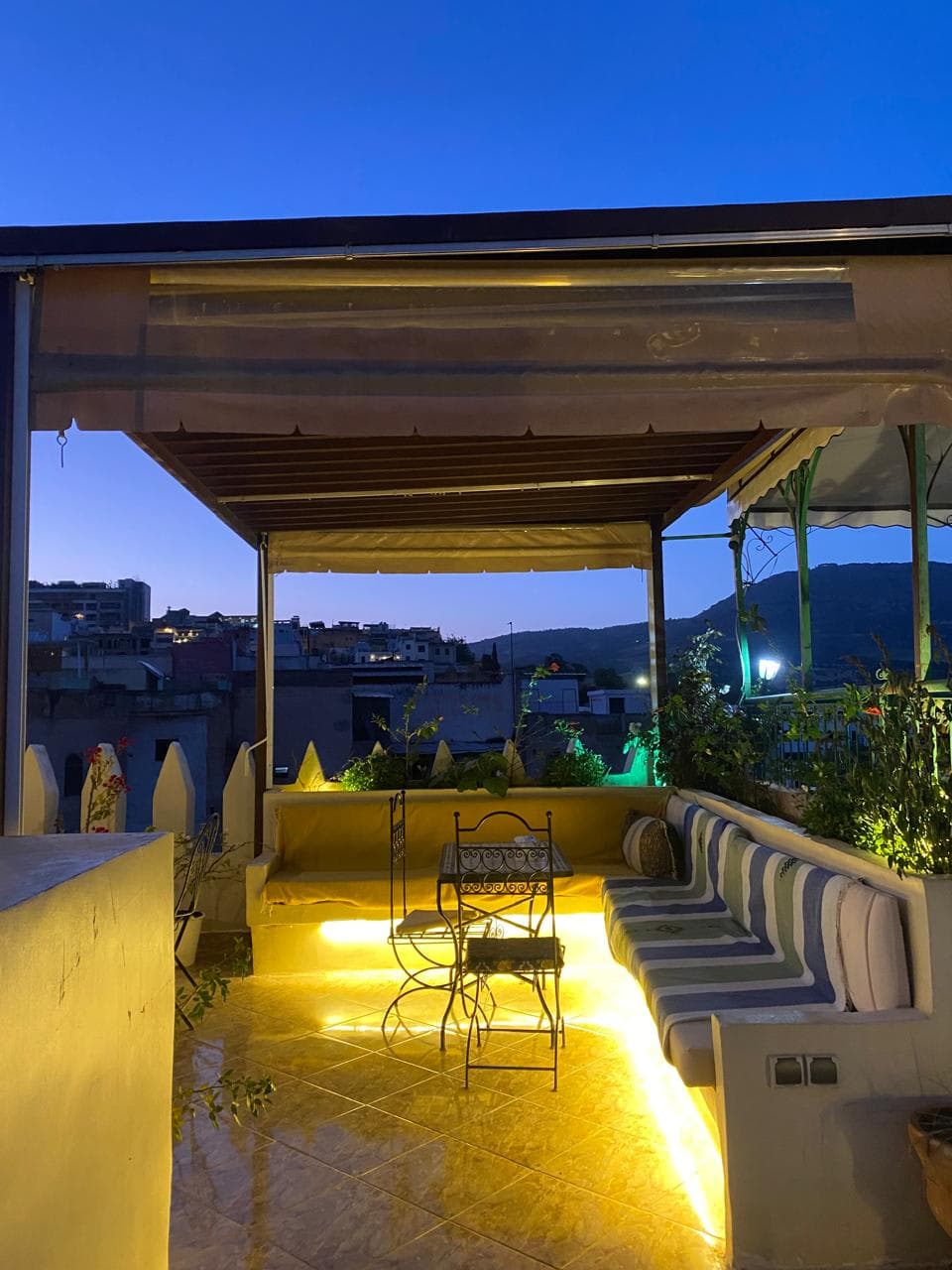 Outdoor rooftop restaurant seating overlooking the historic city of Fes